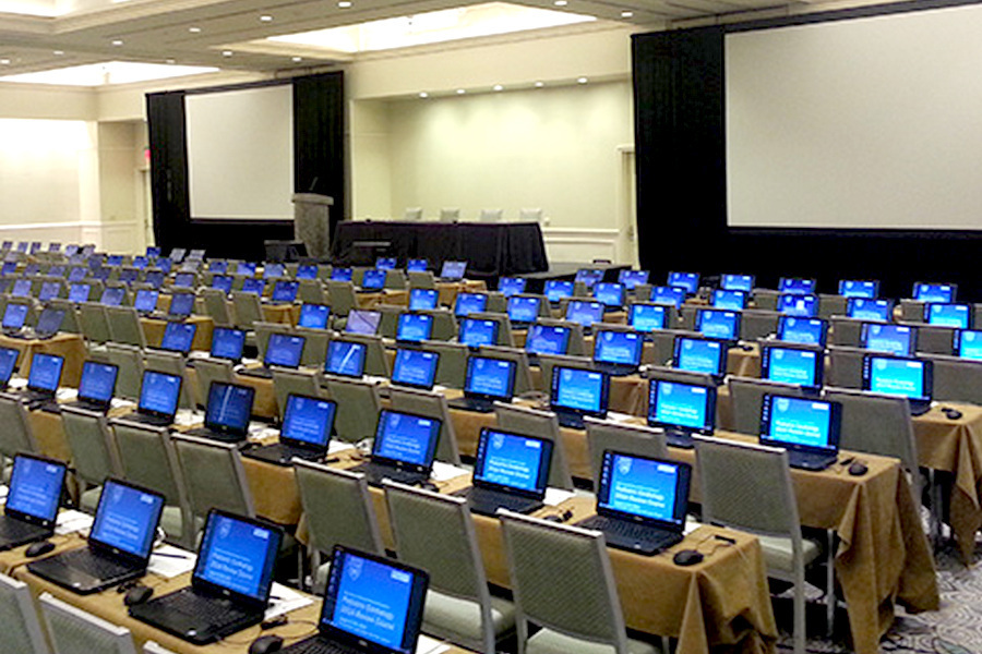 Laptop kompjuteri postavljeni na stolove u praznoj konferencijskoj sali